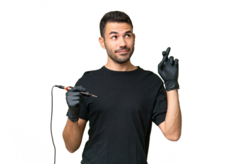 Tattoo artist caucasian man over isolated background with fingers crossing and wishing the best