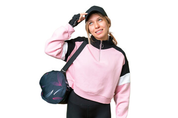 Pretty sport woman with sport bag over isolated chroma key background having doubts and with...