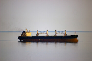 Large ship with yellow taps on board and a smoking chimney