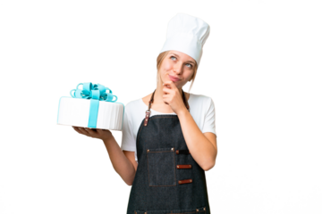 Young pastry blonde woman with a big cake over isolated chroma key background and looking up