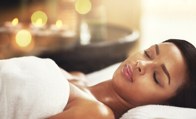 Woman, spa and relax on massage table or sleep, calm and peaceful on holiday vacation or wellness...