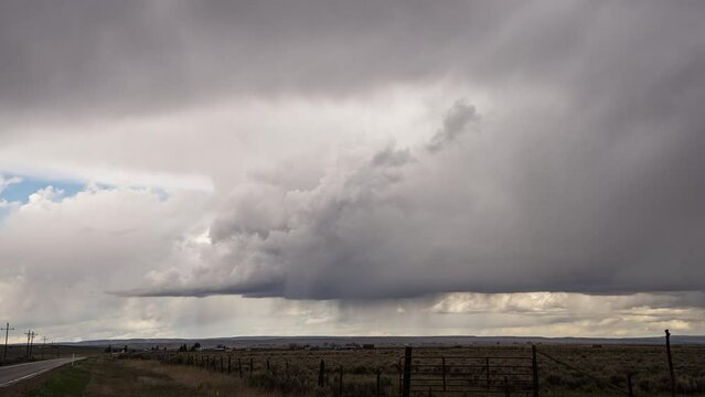 Timelapse of storm moving over the landscape in Utah as rain falls from the sky.