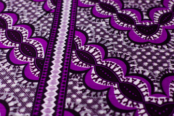 Obraz premium top view of purple ankara fabric, flatlay of nigerian wax cloth with designs, spread out purple ankara material