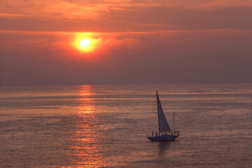 Fototapeta premium People sailing at sunset