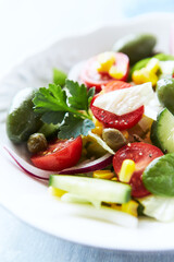 Simple Salad with Green Olives, Cucumber and Cherry Tomatoes. Bright wooden background.