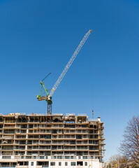 housing crisi: crane working at high rise condo construction site blue sky room for text