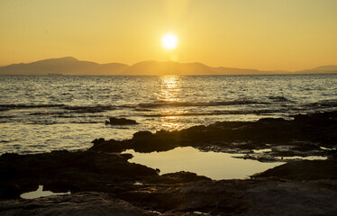 sea coast with stones at sunset, Greece