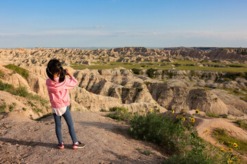 A girl taking photos of the scenery of Badlands National Park in summer, South Dakota