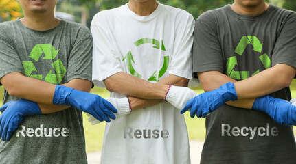 Hands holding hands to reduce, reuse, recycle symbols on green bokeh background. Ecology and earth...