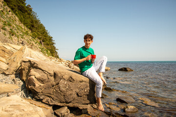A young attractive guy is resting by the sea.