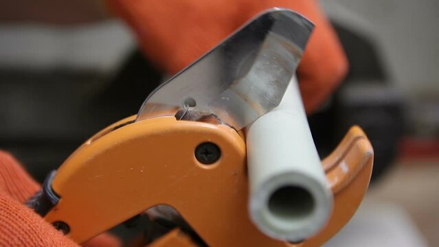 Plumber scissors cuts off the metal-plastic pipe. Pipe cutter for plastic pipes. Side view.