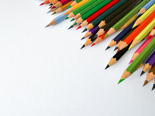Diagonal arrangement of sharp multi colored pencils on white background with empty space for text....