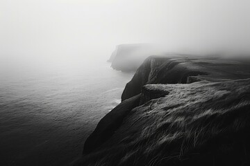b'black and white photo of a rocky cliff edge overlooking a large body of water'