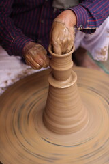 A close-up of a potter's hands skillfully shaping a ceramic vase on the potter's wheel