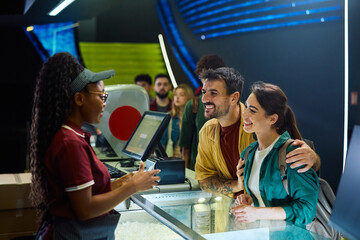 Happy couple at ticket counter in cinema.