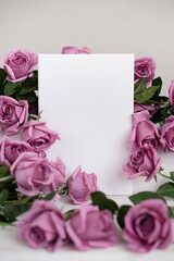 Mockup white poster surrounded by pink roses on a white stand.