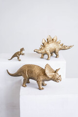 Golden dinosaur figurines on a white background.