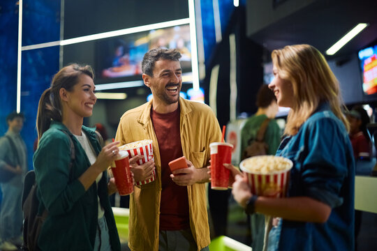 Happy man having fun with his friends in movie theater.
