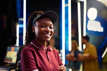 Portrait of happy black cashier working in cinema and looking at camera.