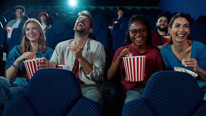Happy friends having fun while watching comedy movie cinema.