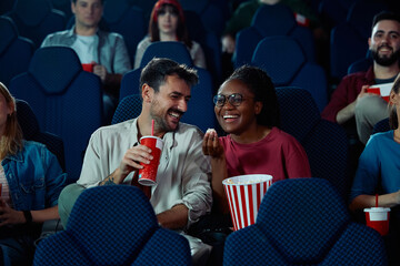 Young happy couple enjoying in movie projection in theater.