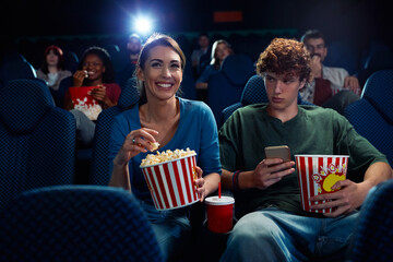 Happy woman enjoying in film screening in movie theater.