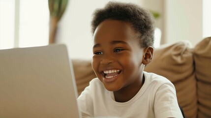 Distance education. Smiling african american child schoolboy studying online on laptop at home. Homeschooling or studying at home.