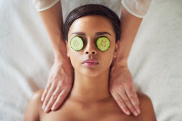Woman, spa and neck massage for relax, masseuse hands and cucumber for dark circles. Resting,...