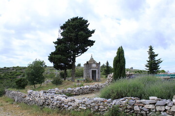 Lavender fields and an ancient chapel near Brusje on the island Hvar, Croatia - obrazy, fototapety, plakaty