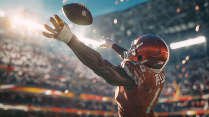 An American football wide receiver is leaping to catch a football mid-air during a game, displaying agility and concentration in a sunlit, packed stadium.