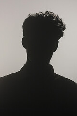 people of ai // silhouette of young man with short curly hair, backlighting, minimalistic, light grey background, photorealistic // ai-generated 