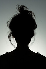 people of ai // silhouette of woman with messy bun hair, backlighting, minimalistic, grey background, photorealistic // ai-generated 