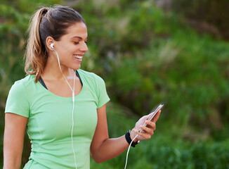 Woman, earphones and smile with smartphone for fitness, exercise and wellness with music in park....