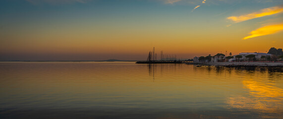 Sunset over the marina in Mèze (France). The golden hour enhances the lights on the Etang de Thau.