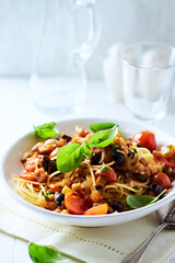 Spaghetti Pasta with Vegetables and fresh Basil on bright wooden Background.