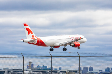 Naklejka premium Mississauga Canada, April 9, 2022; An Air Canada Rouge Airbus A320 clearing the fence at the end of the runway for landing at at Toronto Pearson Airport YYZ