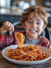 A young boy is eating spaghetti with a smile on his face