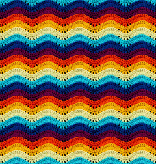 Seamless knitted pattern in the form of openwork waves is crocheted with threads of bright colors....