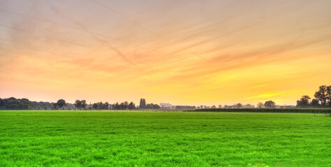 Sunset over the rural meadows of Noord-Brabant, The Netherlands. - obrazy, fototapety, plakaty