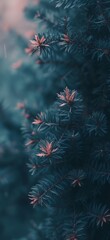 a close up of a pine tree with red leaves on it's branches and a blurry background..
