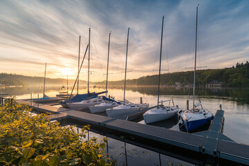 Marina with moored sailboats on Lake Baldeneysee in the city of Essen, beautifully illuminated by...