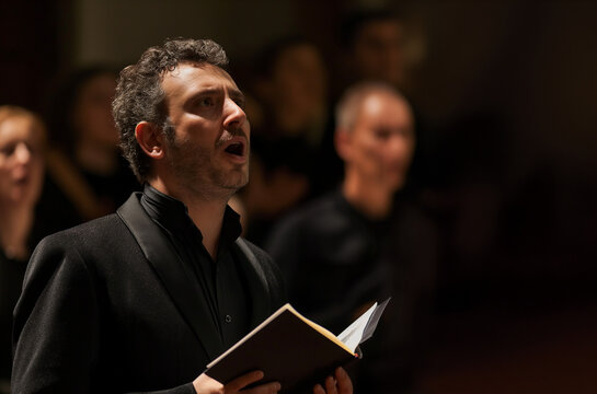 Solo singer during an opera concert. Inspiration, skill, classical music. Opera singer in front of the choir. Applause, success, opera, baroque, music festival.