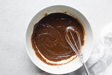 Creaming melted butter brown sugar and egg with a whisk, the process of making a cake, mixing butter, sugar and egg to make a cookie