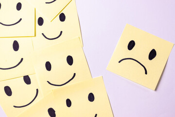 smiley face and sad face on a post it