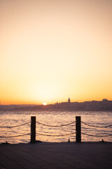 outstanding photography of a sunset in istanbul with the silhouette of the city skyline and the sun getting in near Galata tower, with birds flying around. copy space.