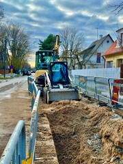 Trench construction with a mini excavator in the residential area 
