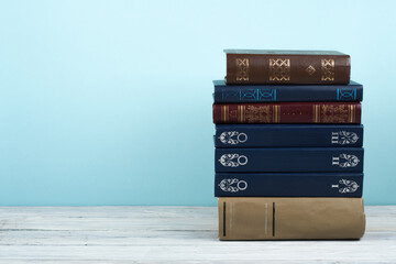 Open stacking book, hardback colorful books on wooden table and blue background. Back to school....
