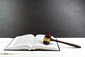Law concept - Open law book with a wooden judges gavel on table in a courtroom or law enforcement office isolated on white table. Copy space for text. - 798134151