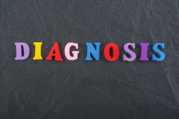 DIAGNOSIS word on black board background composed from colorful abc alphabet block wooden letters, copy space for ad text. Learning english concept. - 798134513