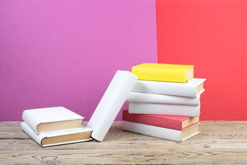 Books stacking. Books on wooden table and red, purple background. Back to school. Copy space for ad...